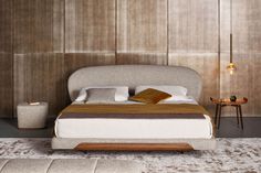 a bedroom with a large bed and wooden paneling on the walls, along with two end tables