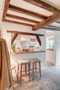 a kitchen with two stools in front of the counter