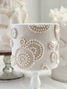 a white cake with beaded decorations on it