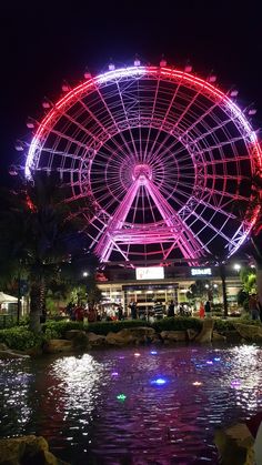 the ferris wheel is lit up at night