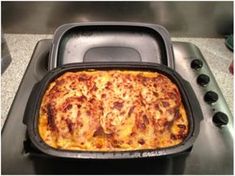 a casserole sitting on top of a stove in a black pan next to an oven burner