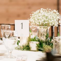 the table is set with flowers, candles and place cards for guests to sit at