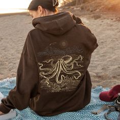 🌊 Octopus Hoodie Sweatshirt for Men and Women | Available in Plus Sizes 🐙 FEATURES: * 50% cotton, 50% polyester (Made from specially spun fibers that make for a very strong, smooth fabric. Polyester fibers are extremely resilient, resistant to most chemicals, stretching, and shrinking.) * Medium-heavy fabric (8.0 oz/yd² (271 g/m * Kangaroo pouch pocket: spacious; keep your hands warm * Classic fit * Tear-away label * Runs true to size * Without side seams; knitted in one piece using tubular knit, it reduces fabric waste and makes the garment more attractive * Drawstring hood, adjustable hood with self colored woven cord ♥️ Do you want to miss out on shop details? Of course not! So click the heart icon to favorite our shop SUN&RANE and let's keep in touch.  👀 SEE more items from this sho Cotton Relaxed Fit Hoodie For Vacation, Hooded Cotton Top For Vacation, Cotton Hooded Top For Vacation, Casual Cotton Hoodie For Vacation, Cotton Hoodie Tops For Vacation, Cotton Hoodie Tops For Beach Season, Casual Hoodie Tops For Beach Season, Casual Vacation Hoodie Top, Long Sleeve Cotton Hoodie For Beach Season