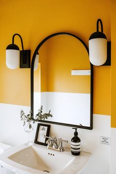 a bathroom sink sitting under a mirror next to a wall mounted light