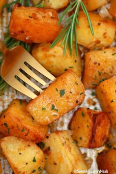 roasted potatoes with rosemary garnish and a fork