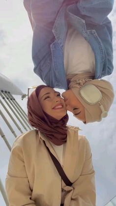 two women wearing headscarves and scarves standing next to each other