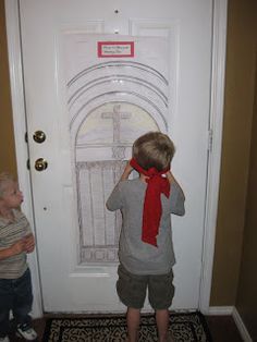 two young boys standing in front of a door with a red scarf on their head