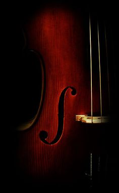 a violin is shown in the dark with its strings still attached to it's body