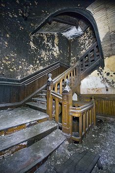 an old run down building with some stairs and railings in the middle of it