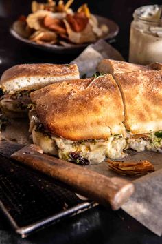 a sandwich cut in half sitting on top of a cutting board