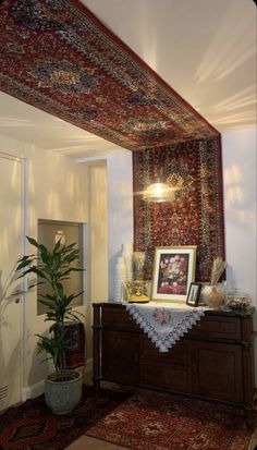 a living room area with rugs, potted plants and pictures on the wall