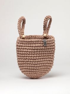 the small basket is made from woven material and has two handles on each side, one with