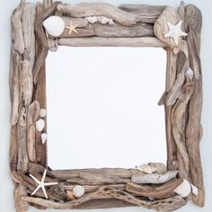 a frame made out of driftwood with shells and starfish