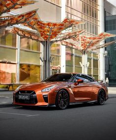 an orange sports car parked in front of a building