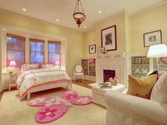 a bedroom with a bed, fireplace and two chairs in front of the fire place