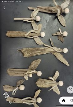 several pieces of driftwood are displayed on a black surface with white balls and wood sticks