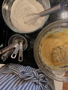 two bowls with whisks and flour in them