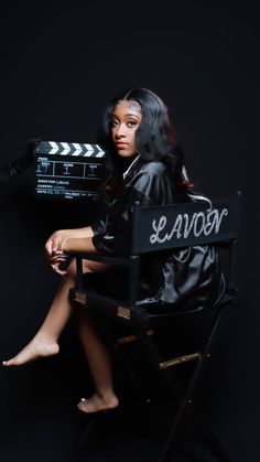 a woman sitting in a chair with a movie clapper on her arm and legs