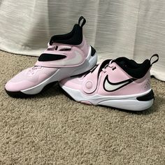 pair of pink and black nike shoes on carpet