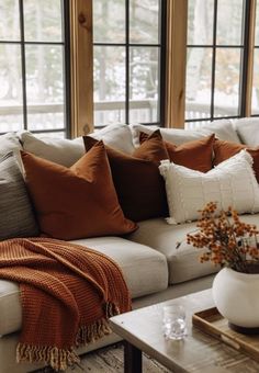 a living room filled with lots of furniture and pillows on top of a white couch