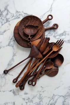 wooden utensils and spoons are arranged on a marble surface