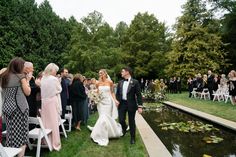 a bride and groom walking down the aisle after their wedding ceremony at an outdoor venue