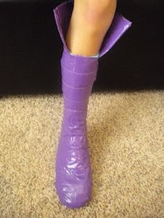 a woman's foot wearing purple boots with her leg wrapped around an object on the floor