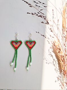 a pair of beaded earrings sitting on top of a table