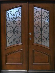 a double door with glass and wrought iron design