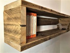 a book shelf made out of wood with two books on each shelf and an animal figurine