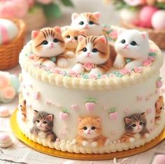 a cake decorated with kittens sitting on top of it and surrounded by other cats