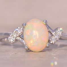 an opal and diamond ring on a table