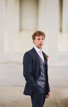 a young man in a suit and pink tie