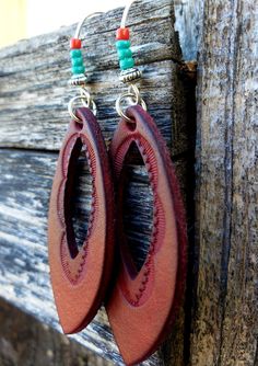 Hand-tooled and dyed a beautiful rust color, these simple earrings are crafted from premium veg-tanned leather. Four dainty glass beads add a pop of color, in this Southwestern designed pair.   These earrings are conditioned with beeswax, which keeps the leather supple and water resistant (as seen in video). Edges and backs are finished, as well. Please remember that time and wear ages leather beautifully, transforming your pieces into truly personalized jewelry.  Earrings come with antiqued bra Bohemian Hand-tooled Leather Earrings, Handmade Rustic Leather Earrings, Rustic Hand Tooled Leather Earrings, Earthy Brown Earrings For Festivals, Handmade Rust Leather Jewelry, Everyday Hand-tooled Leather Jewelry, Everyday Hand Tooled Leather Jewelry, Handmade Leather Earrings For Festivals, Festival Handmade Leather Earrings