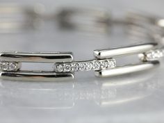 This white gold and diamond link bracelet is quite lovely, crafted in 14K white gold, giving it a luxurious feeling on the wrist. Bright diamonds are pave set in every other link, giving the bracelet an elegant profile. This piece closes securely, with an added locking clasp for safety. Metal: 14K White Gold Gem: 72 Diamonds totaling 1.62 Carats, H in Color, SI3 in Clarity Gem Measurements: 1.3 mm, Round Width: 5.8 mm Length: 7 1/2 Inches Marks: "14K" Stamped on the clasp Luxury Diamond Bracelets With Rectangular Links, Luxury White Gold Rectangular Diamond Bracelet, Luxury Anniversary Jewelry With Rectangular Links, Luxury White Rectangular Stone Jewelry, Luxury White Gold Sterling Silver Bracelet With Complimentary Chain, Luxury Rectangular Jewelry With Pave Setting, Luxury Rectangular Jewelry With Diamond Hour Markers, Luxury White Rectangular Bracelet, Luxury Diamond Bracelet With Rectangular Links As Gift