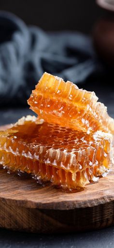 two pieces of honey sitting on top of a wooden cutting board