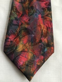 London fashion icon Hardy Amies designed this textured, richly colored multi-colored abstract and floral print tie, with highlights of rust, purple, green. (The picture doesn't do it justice!) I'm not sure of the year, but I know it's vintage. Buy more than one item from me at the same time, and you'll get 10% off all the lower priced items! (Plus save on shipping!) Please take a look at my storefront at: https://www.etsy.com/shop/FabFinds42?ref=seller-platform-mcnav I have a wide selection of o Elegant Multicolor Standard Tie, Elegant Multicolor Neckwear With Ties, Elegant Multicolor Ties As A Gift, Adjustable Multicolor Neckwear For Gift, Multicolor Standard Tie For Summer, Multicolor Summer Ties For Formal Occasions, Multicolor Adjustable Tie For Formal Occasions, Multicolor Neckwear As A Gift, Adjustable Multicolor Standard Tie