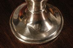 an old fashioned silver candle holder on a wooden table