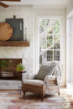 a living room filled with furniture and a fire place next to a wall mounted clock