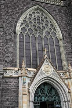 an old church with a clock on it's front door and stained glass windows