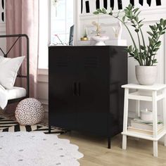 a room with a black cabinet and white rugs on the floor next to a window