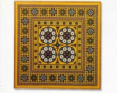 a cross - stitch pattern with four circles on it, in yellow and brown colors