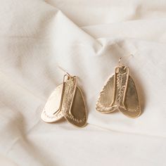 Made in house by Cire' Alexandria Highly detailed moth earrings are hand stamped one little line at a time! Given a soft brushed finish so each detail stands out, even small wire antenna. Slightly folded to give a more 3D appearance. Hung on 14K gold filled ear wires. MEASUREMENTS | dangle 2” long, 1 1/2” at widest point. Large Moth, Moth Earrings, Insect Jewelry, Earrings Design, Tiny Earrings, Wing Earrings, Diamonds And Gold, Large Earrings