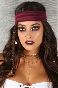 a woman with long hair wearing a headband and choker necklaces is posing for the camera