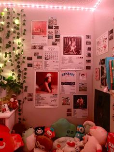 a room filled with lots of stuffed animals next to a wall covered in posters and lights