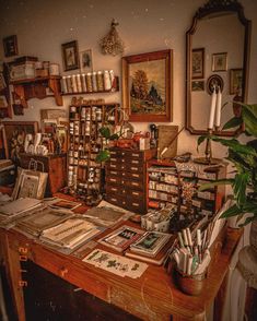 an old fashioned desk with lots of books and pictures on the wall, along with other antique items