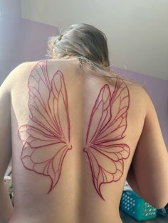 a woman's back with a butterfly tattoo on it