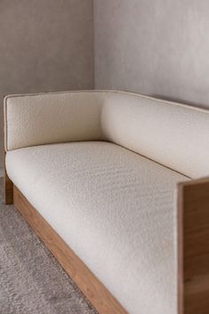 a white couch sitting on top of a carpeted floor next to a wooden frame