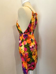 "Original to the 60s. Fab MINI Dress!! Bright bold floral pattern. Front cut out detail at chest, toe back neck, hidden back zipper and button closure. Mannequin is a US Size 4, and the dress fits her like a glove, for your sizing reference. Measurements laying flat - The high waist is empire style and hits just below the bust. Measures 13\" laying flat. Total length of dress is 31\" (mini dress) The halter style neck ties at back Tiki Time!" Fitted Halter Neck Floral Dress For Garden Party, Fitted Halter Neck Floral Dress, Fitted Floral Print Backless Mini Dress, Vintage Backless Party Dress, Summer Floral Print Mini Dress For Cocktail, Summer Floral Print Cocktail Mini Dress, Retro Cocktail Mini Dress, Retro Floral Print Knee-length Mini Dress, Retro Knee-length Mini Dress With Floral Print