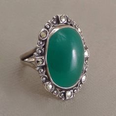 "See More Antique Jewelry here: https://www.etsy.com/shop/YearsAfter?search_query=antique An Exquisite Antique Art Deco Sterling Ring embellished with Chrysoprase or Green Chalcedony Gemstone with a Scroll Frame of Brilliant Prong-set Marcasites on a Long Sterling Silver Setting with Split Shank Sides, Hallmarked STERLING, Size 5, Weight 4.9 grams circa 1920's! Measurements: Size 5 Close Fitting (5 US). Face is approx. 1\" height by 3/4\" across. Band is about 1/8\" in width. This Chrysoprase Ri Green Cabochon Art Deco Rings, Art Deco Green Cabochon Rings, Green Cabochon Rings In Art Deco Style, Vintage Chrysoprase Ring Jewelry, Art Deco Green Oval Emerald Ring, Antique Green Emerald Ring, Vintage Emerald Ring Gift, Antique Green Emerald Ring Collectible, Antique Handmade Green Emerald Ring